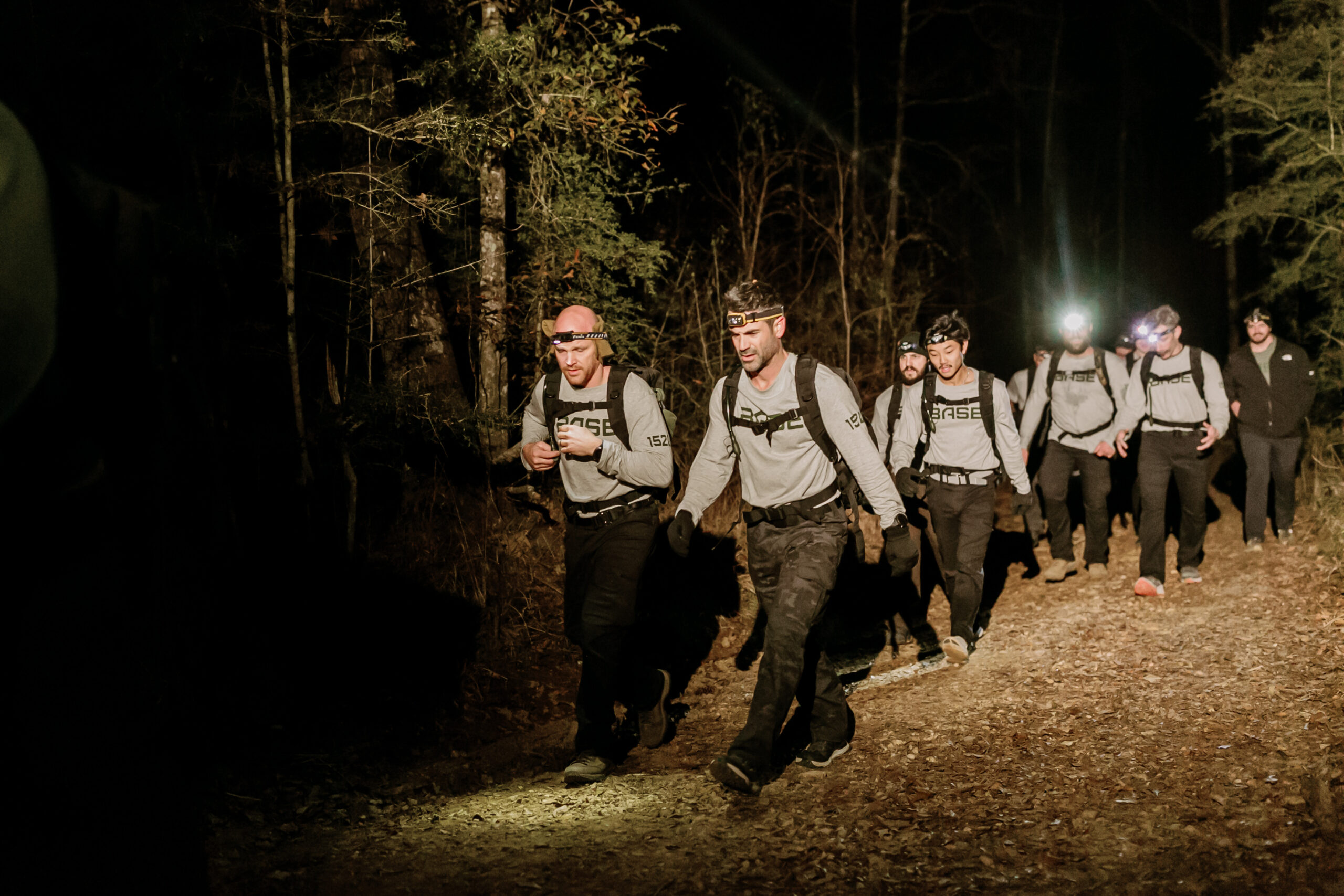 Missionary candidates rucking at night with headlamps during BASE 1520 field training